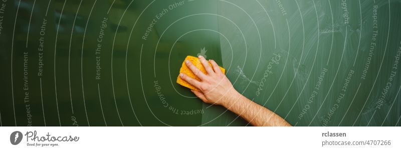 Teacher Hand cleaning dirty green chalkboard with sponge, blackboard texture background with copy space, banner size eraser hand wet school teacher student