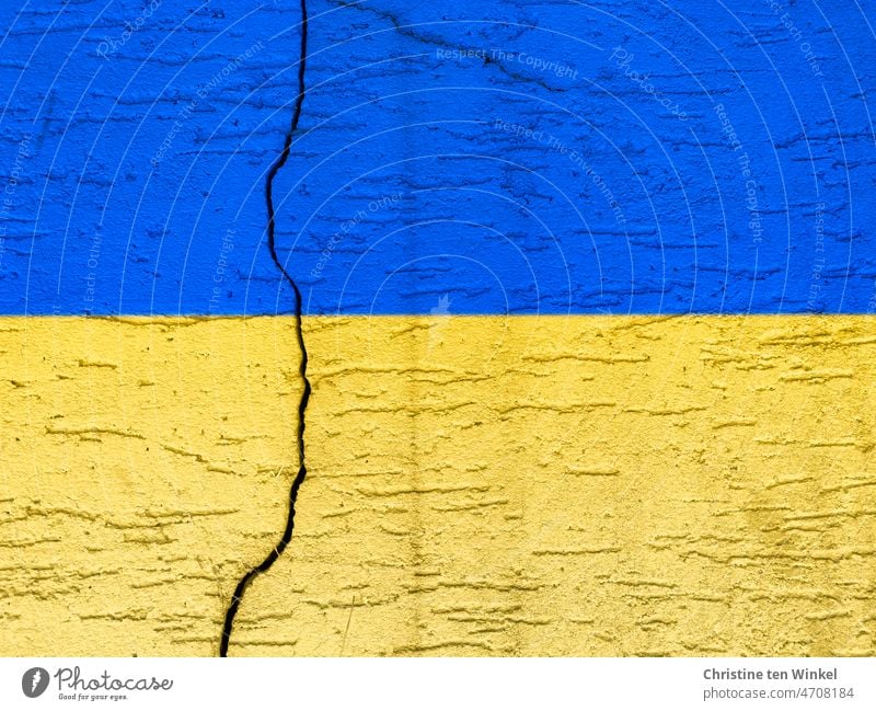 Concrete wall with a clear crack in the national colors of Ukraine ukrainian colors peril War Ukrainian flag war in ukraine background Conflict Ukraine war