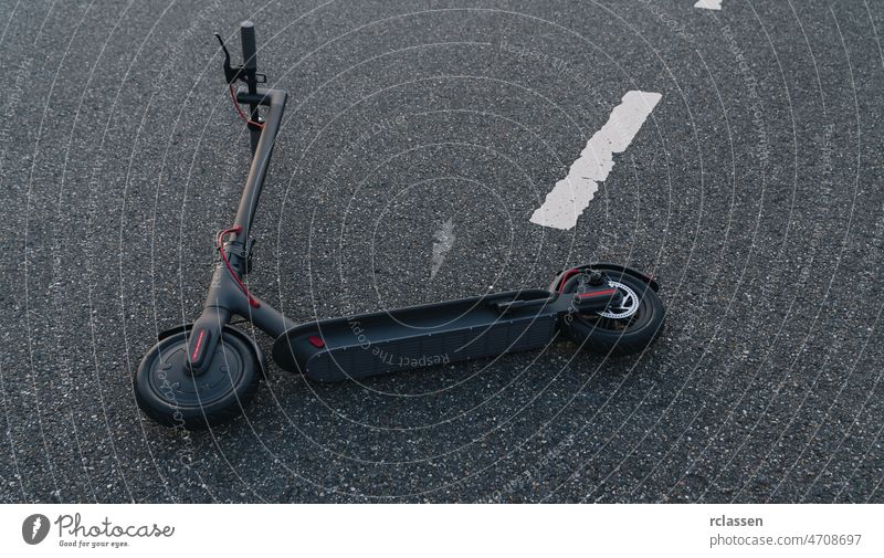 electric scooter or e-scooter lies on the road after a accident, Electric urban transportation concept image city kick downtown sneakers bike drive danger crash
