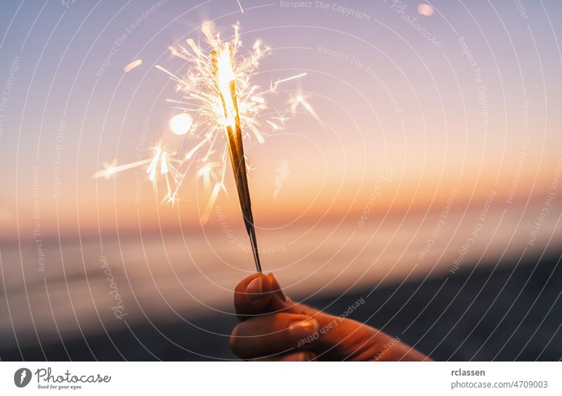 holding sparklers at beach firework night girl party people summer woman abstract background burning celebration flame glow sunset young beautiful beauty