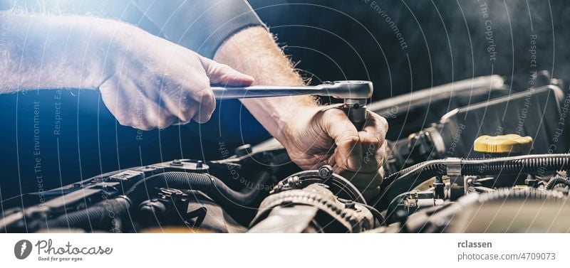 Auto mechanic working on car engine in mechanics garage. Repair service. authentic close-up shot, banner size repair auto grease machine man diy equipment