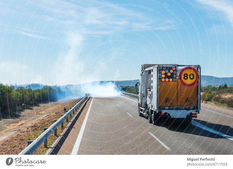 Painting machine of the lines of the road forming a cloud of smoke when working. painting truck marks maintenance roadway special vehicle danger works