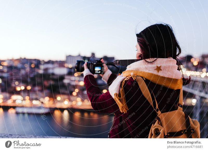 woman in Porto bridge taking pictures with camera at sunset. Tourism in city Europe. travel porto tourist enjoy 30s relax holidays vacation urban high