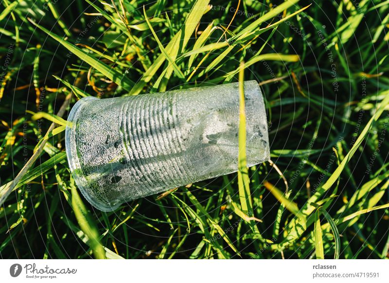 Plastic cup pollution on a meadow plastic abuse bottle chemical city glass waste recycle trash rubbish dirty contaminants contamination cups dangerous dispersed
