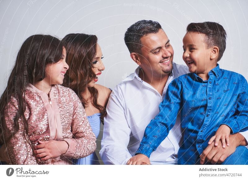 Cheerful family caressing in studio children hug parenthood relationship love childhood cuddle enjoy bonding together daughter son mother father sibling
