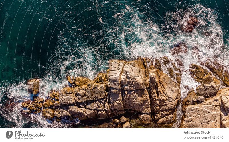 Foamy waves of sea splashing on rocky shore in sunlight cliff seascape seashore nature picturesque ocean coastline power landscape breathtaking girona catalonia