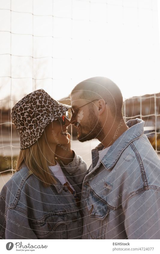 Girlfriend and boyfriend in the fence looking each other and touching noses. Happy couple. hands girlfriend woman love together young relationship romantic