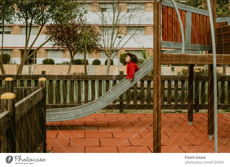 Girl with red jacket playing on the slide Playground playground equipment Slide having fun Playing Joy Infancy Child Leisure and hobbies Kindergarten