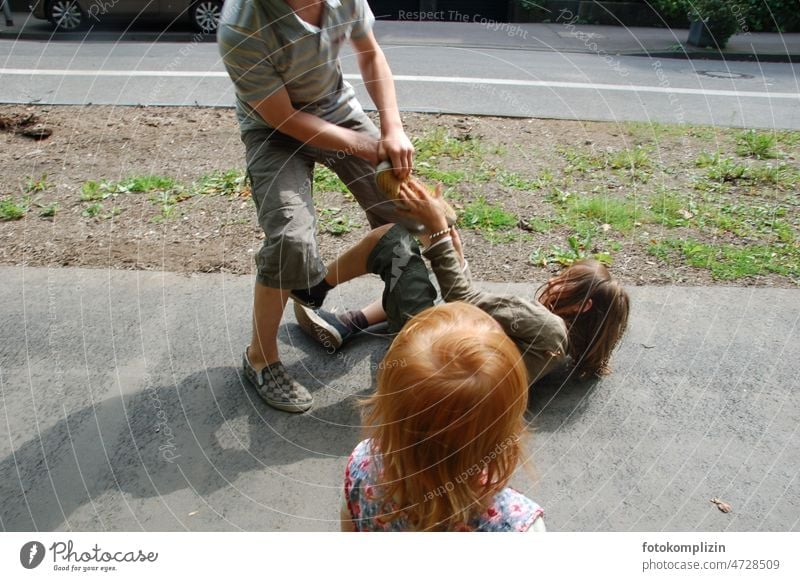 two boys scuffle on a sidewalk and a redheaded girl looks on Fight call children Guys Infancy Children's game Social life Playing fun Playful argue pedagogy