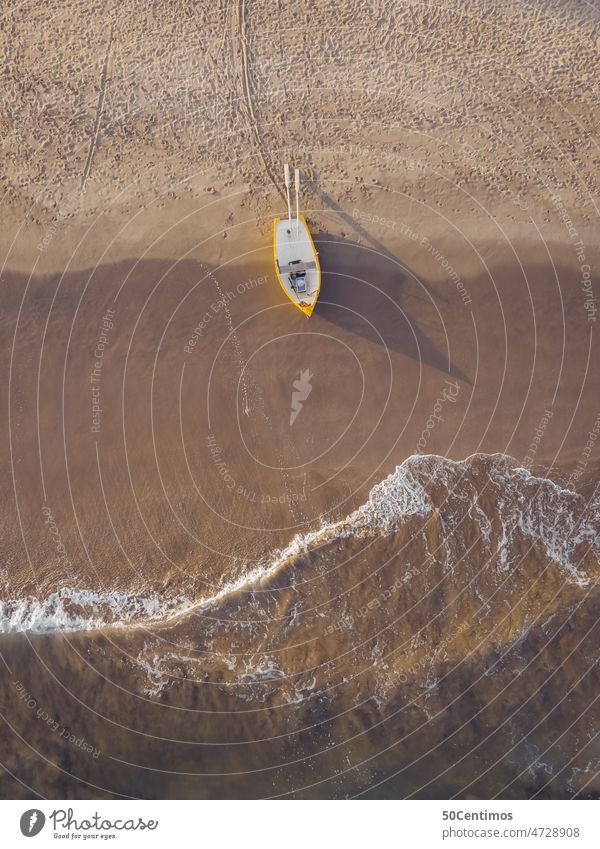 Lonely fishing boat on beach UAV view Aerial photograph Downward Fishing boat coast Beach Rowboat Yellow Sand Sandy beach Waves Ocean Shadow Sunlight