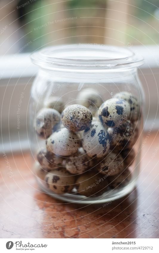 A jar with quail eggs stands on a windowsill Easter Quail eggs Spring Window Glass bins celebrations Seasons Easter egg Feasts & Celebrations Egg Tradition
