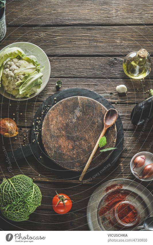 Food background with wooden cutting board, cooking spoon and healthy ingredients food background savoy cabbage cauliflower tomatoes spices herbs onion rustic