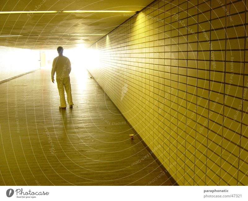 Light in the station Man Multiple Yellow Back-light Lighting Illuminate Shadow play Against Coffee mug Cardboard Floor covering Long Underground Station