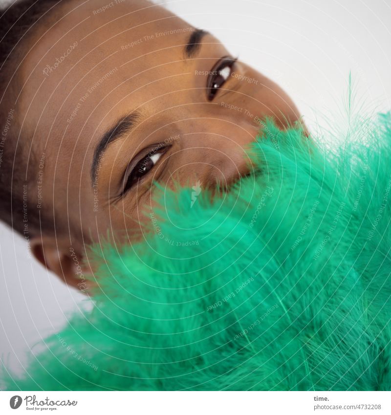 Woman with feather fan portrait Looking into the camera Colour Guide Impish Smiling Observe Warmth Soft Watchfulness Curiosity Respect Interest Esthetic