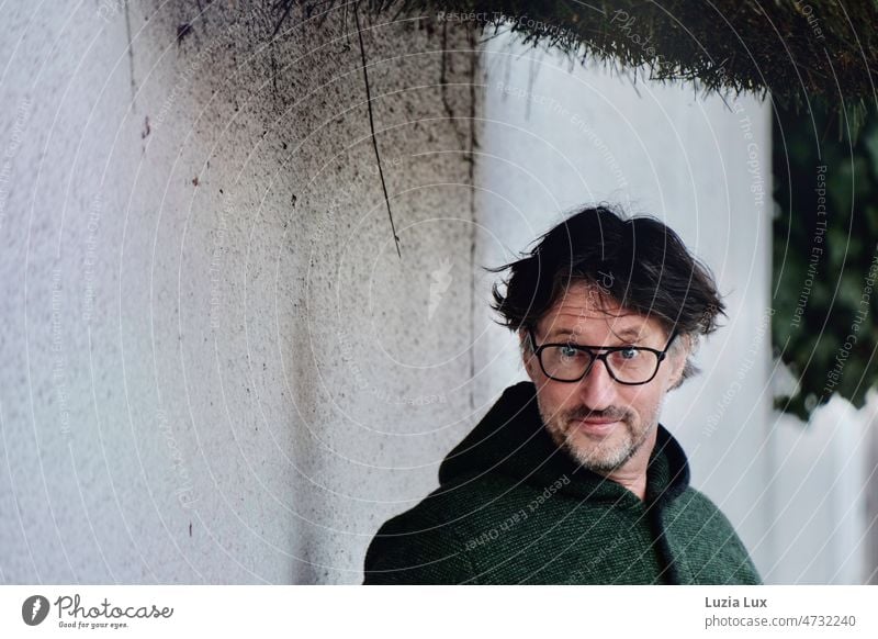 Man in green Janker looks silly from behind his glasses Green cardigan Eyeglasses foolish astonished surprisingly Adults Facial hair Designer stubble pretty