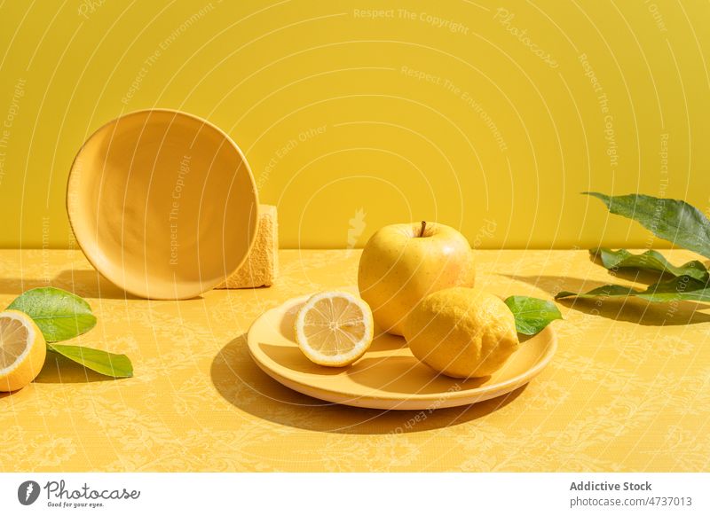 Bright composition of ceramic plate with lemon and apple citrus vitamin halved yellow fruit ripe healthy concept food vivid delicious vibrant tasty exotic
