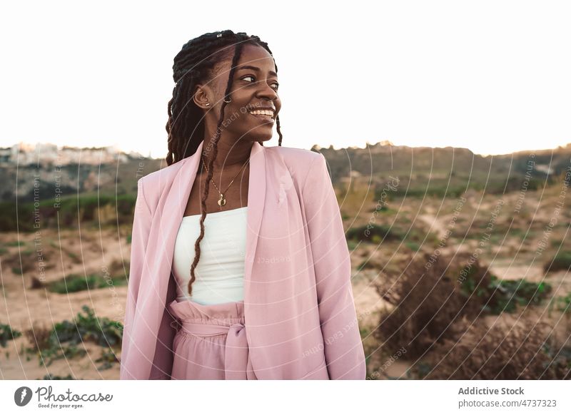 Smiling black woman in highlands in evening positive sunset mountain suit smile summer well dressed female african american ethnic style cheerful content