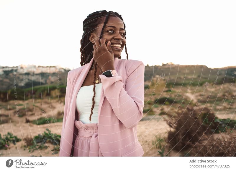 Smiling black woman in highlands in evening positive sunset mountain suit smile summer well dressed female african american ethnic style cheerful content