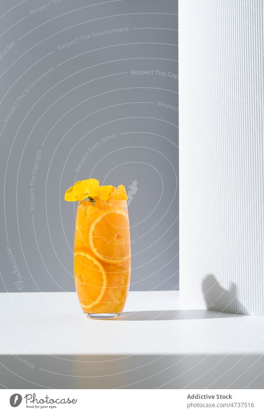 Glass of refreshing orange drink served on white table juice beverage glass sunlight refreshment flower delicious tasty bright citrus healthy detox vitamin