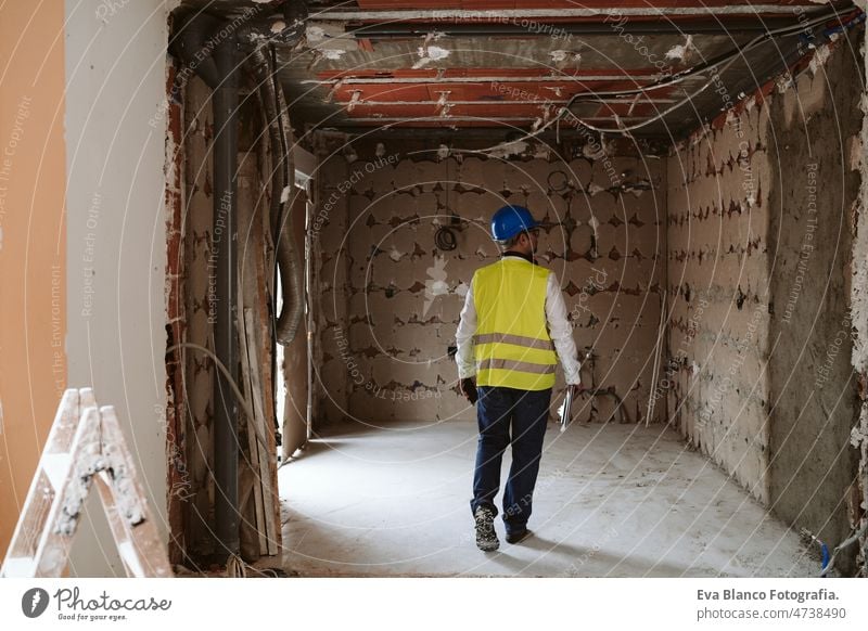 foreman or unrecognizable architect working on blueprints on construction site. Home improvement house professional insulating ear defenders worker industry