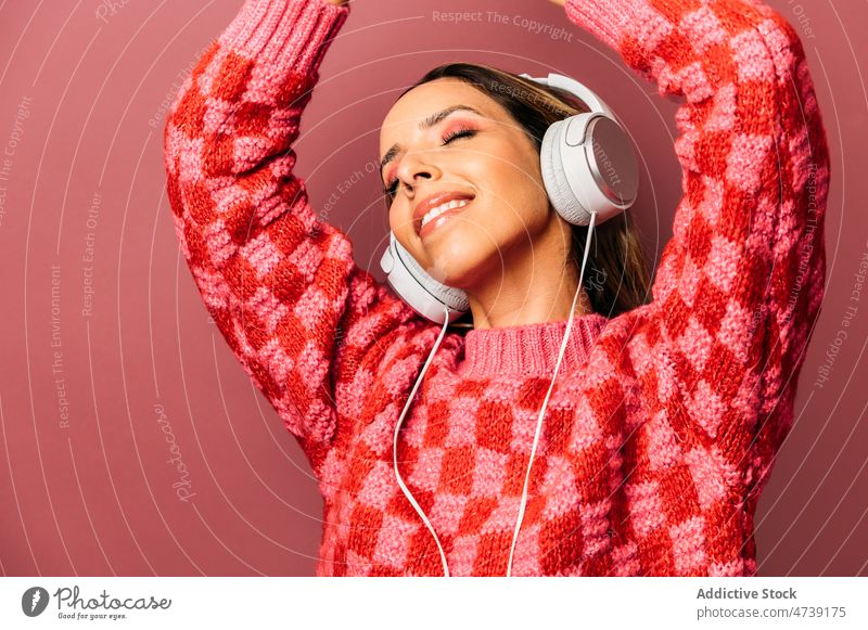Excited woman listening to music in studio headphones song leisure hobby enjoy meloman melody style design feminine trendy lady charming gorgeous female