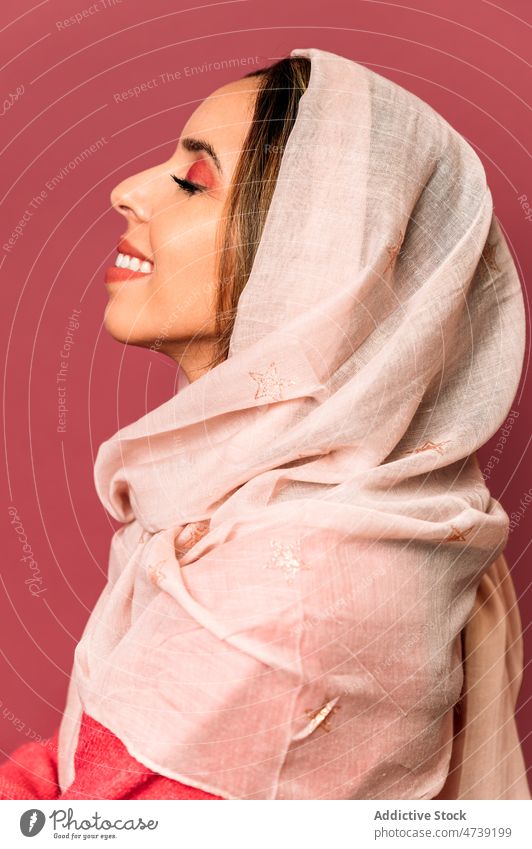 Positive woman in headscarf in studio style makeup feminine design trendy fashion cosmetic charming eyes closed pink female attractive model young sensitive