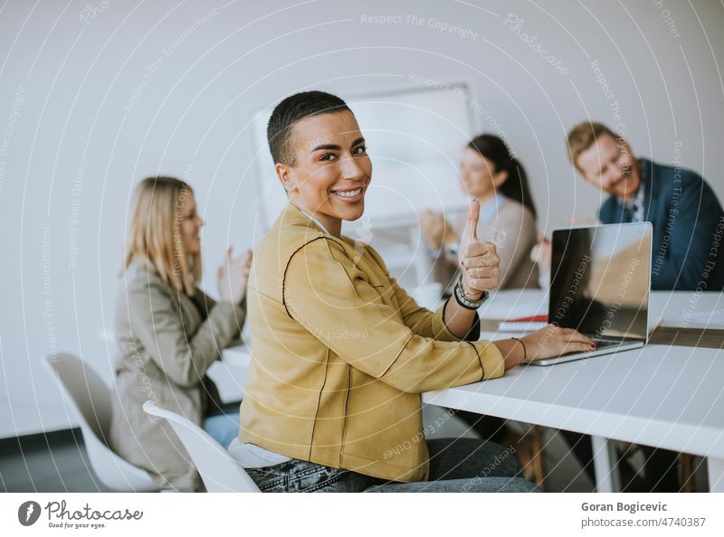 Young short hair business woman sitting in office and using laptop with her team adult attractive businesswoman career caucasian corporate entrepreneur
