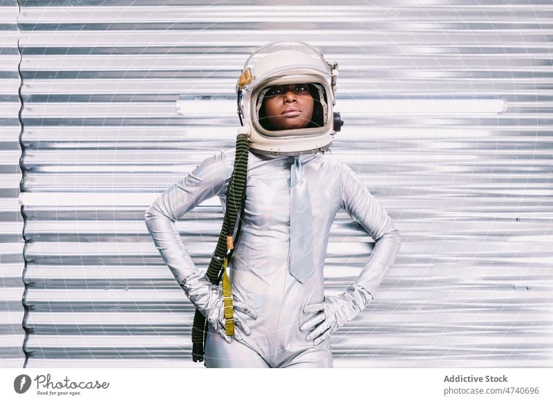 Black woman in spacesuit with helmet astronaut spaceship cosmonaut costume modern profession uniform mission safety african american black light lady confident