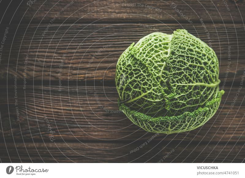 Food background with close up of whole raw green savoy cabbage food background rustic wooden kitchen table healthy garden vegetable top view copy space above