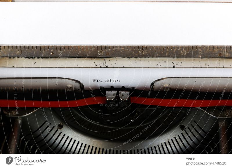The German word Frieden written on an old mechanical typewriter German Text: peace Letter Stop Typewriter ancient black ink ribbon keypad keys mechanics metal