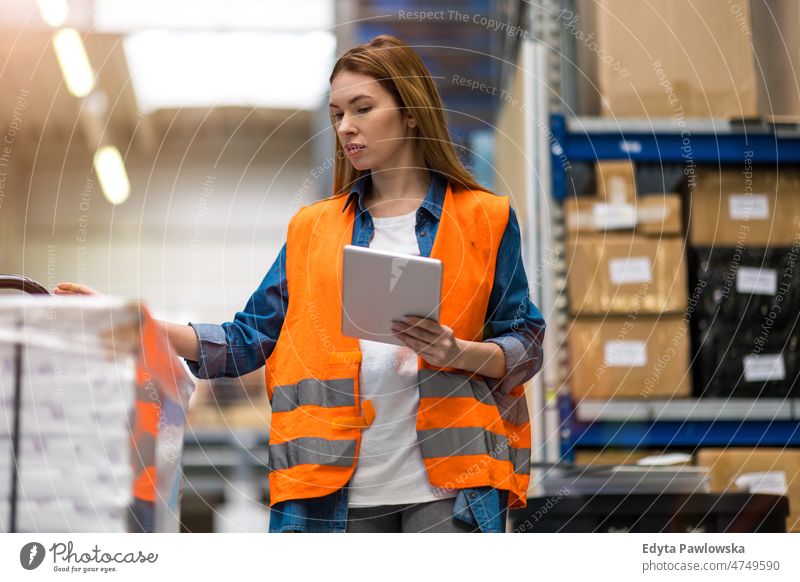 Woman with tablet in factory storehouse checking location of goods business cargo confident delivering delivery distribution employee female industrial industry