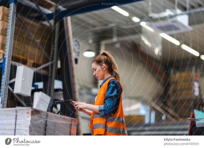 Woman with tablet in factory storehouse checking location of goods business cargo confident delivering delivery distribution employee female industrial industry
