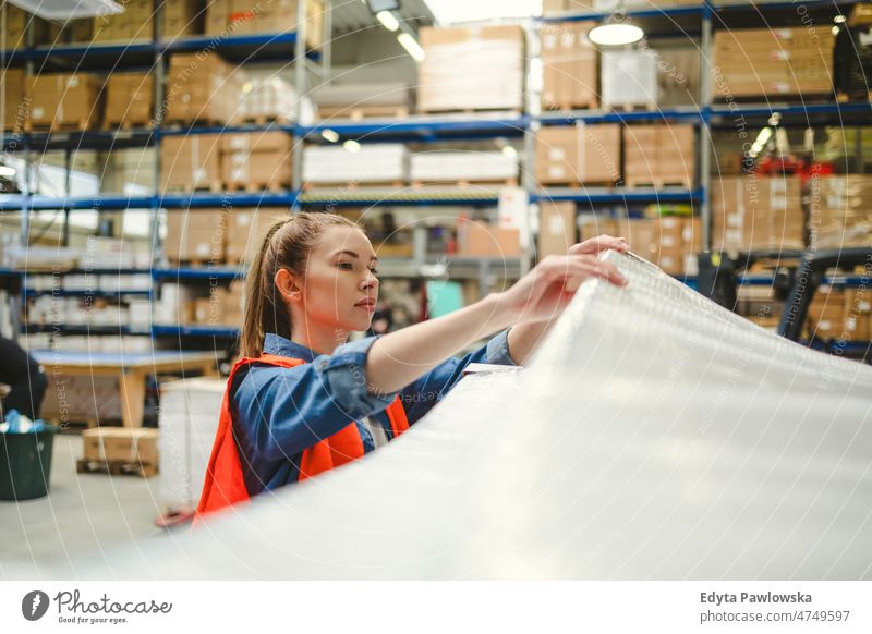 Young woman working in an industrial place of work business cargo confident delivering delivery distribution employee factory female goods industry job