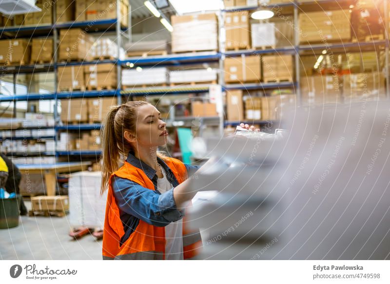 Young woman working in an industrial place of work business cargo confident delivering delivery distribution employee factory female goods industry job