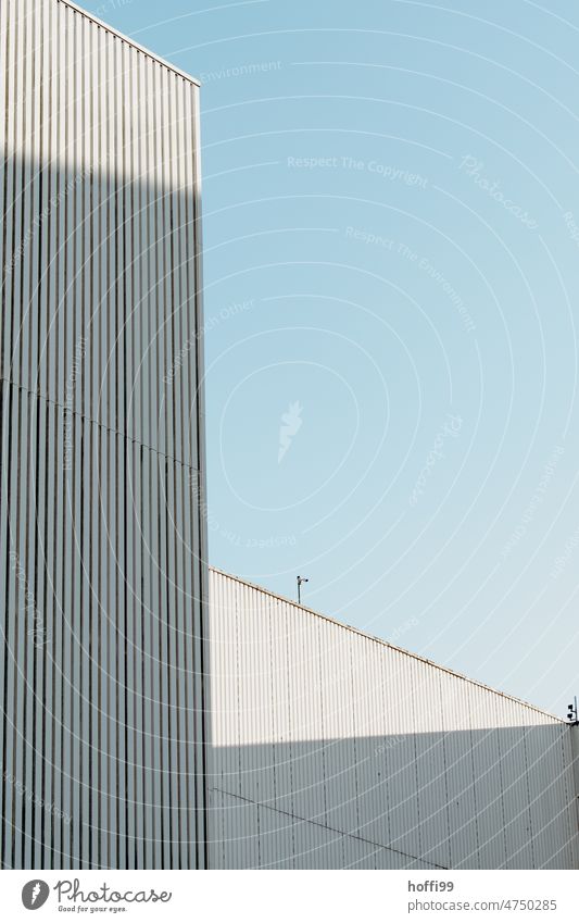 White corrugated metal facades of warehouse in harbor against blue sky Architecture Harbour industrial facade Blue sky Storage Flake Corrugated sheet iron