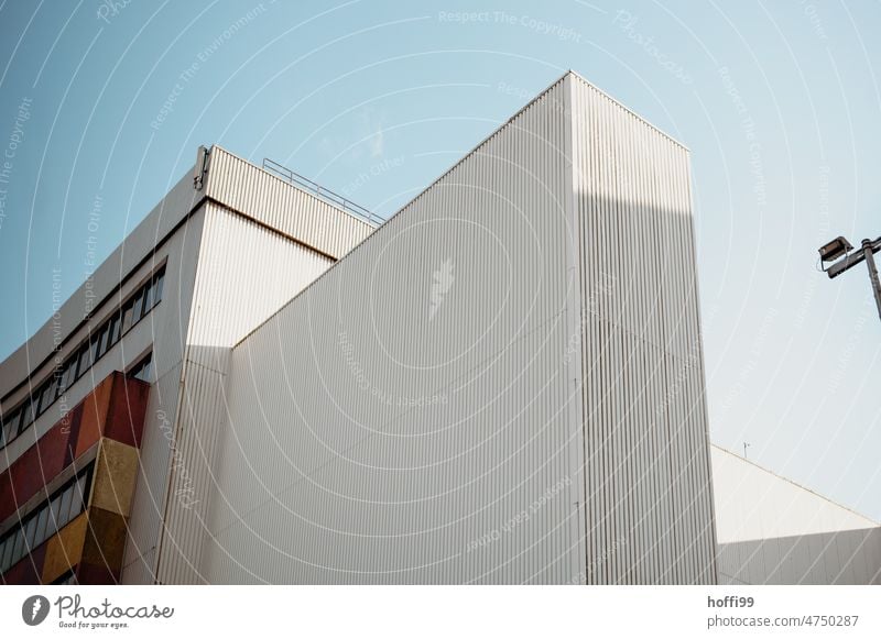 White corrugated metal facades of warehouse in harbor against blue sky Architecture Harbour industrial facade Blue sky Storage Flake Corrugated sheet iron