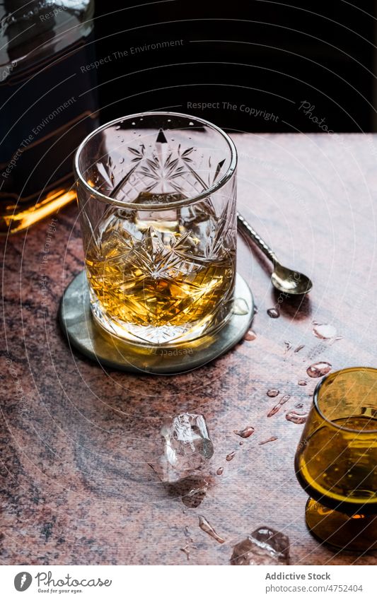 Glass of whiskey on restaurant table ice alcohol glass wet service portion spoon drink beverage liquor rocks broadway pub crystal exquisite cool cold aperitif