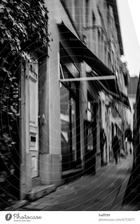 blurred city scene with sidewalk, passersby and stores Sidewalk Passers-by dreariness blurred background Group Cobbled pathway Lanes & trails Cobblestones