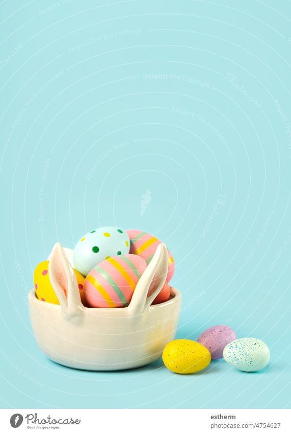Happy Easter. Colored easter painted eggs in a bunny ears bowl with copy space happy easter abstract sweet still life chicken colored easter rabbit
