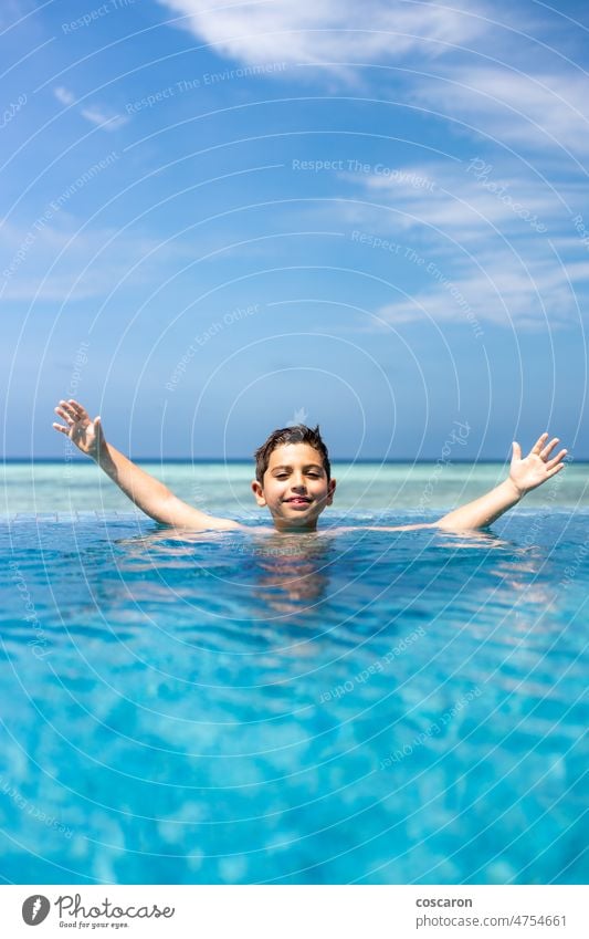 Little kid in a infinity pool near the ocean adorable alone beach blue boy caucasian cheerful child childhood coast cute fun happiness happy holiday island