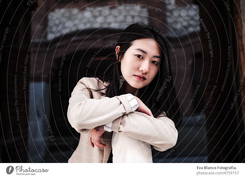 close up portrait of confident chinese woman in city leaning on wall lifestyle modern business entrepreneur asian beautiful ethnic international face attractive