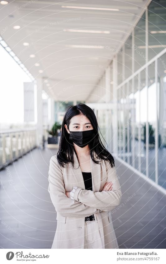 young business woman wearing face mask in city. corona virus concept chinese pandemic office co working glass reflection asian entrepreneur professional