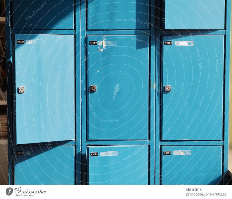 Old blue dented lockers in sunlight Lockbox Locker Cupboard Bulge Key Digits and numbers Metal Arrangement Safety Colour photo Dented Broken corrupted Keep