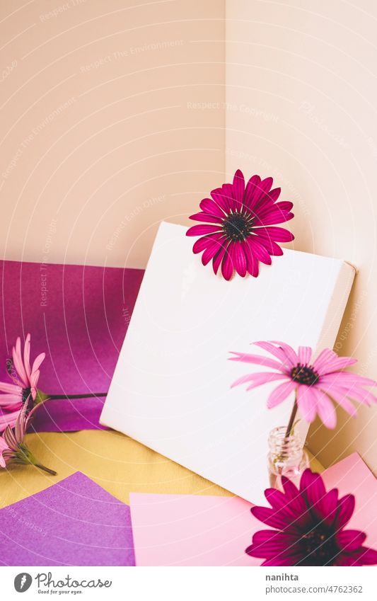 Mockup image with a white canvas surrounded by color papers and flowers mockup spring design colorful vibrant post-it sticky notes yellow purple pink tones