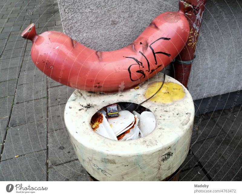 Trash can in front of a sausage stand with oversized beef sausage on a street corner in downtown Frankfurt am Main in Hesse, Germany Small sausage Imbuss