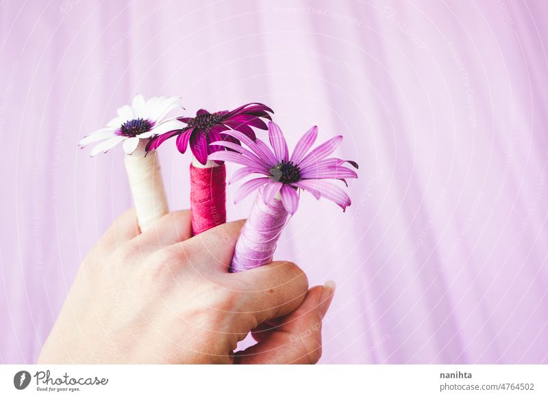 Close up image with a concept between flowers and couture sewing thread floral purple tones pink beautiful fashion trendy palette new organic cotton hand hold