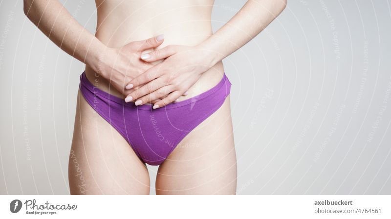 woman in panties holding belly with abdominal or period pains - a