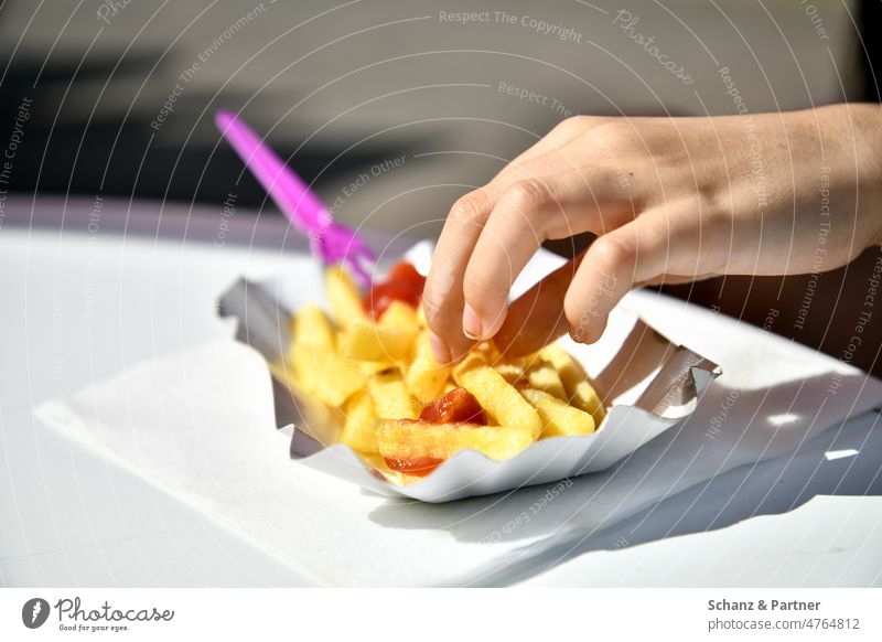 Hand takes a french fry from cardboard bowl on white table Fast food Ketchup French fries Eating Nutrition Food Delicious Unhealthy Snack bar Potatoes Fat