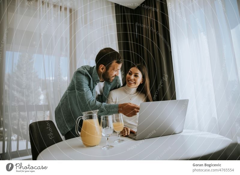 Young couple using laptop computer on the table in the living room people love woman movie boyfriend caucasian happy couch husband media house watching modern