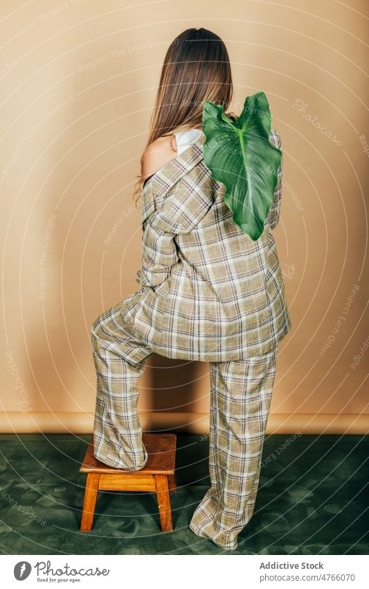 Woman in classy suit with green branch in studio woman model elegant style formal leaf trendy checkered female plant jacket studio shot feminine outfit